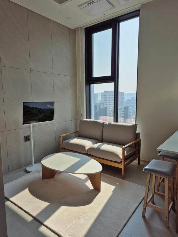a living room with a couch and a coffee table at Center of Seoul, Newly built high floor house with view in Seoul