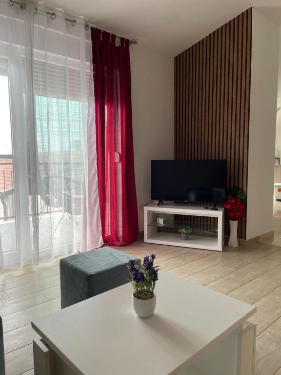 salon z telewizorem i białym stołem w obiekcie Apartmani Krišto 2 Zadar w mieście Zadar