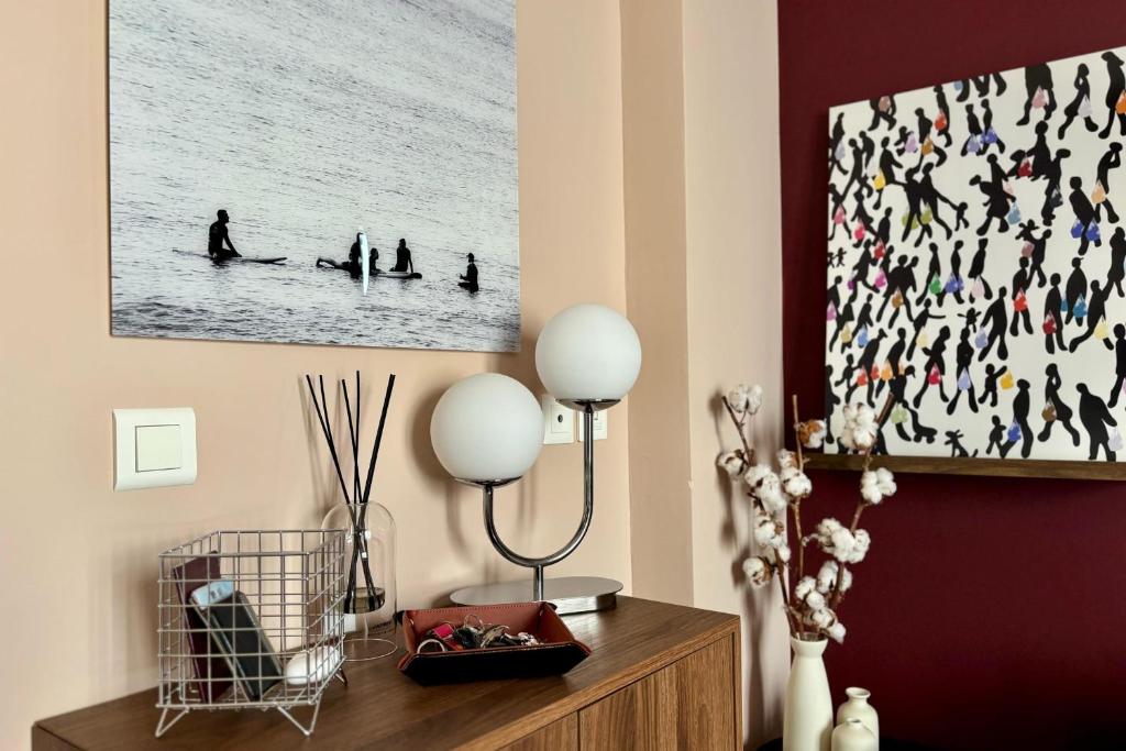 un salon avec une photo de personnes dans l'eau dans l'établissement Charming T2 with terrace near beach, à Biarritz