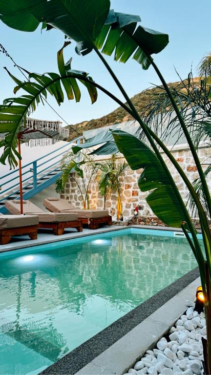 a pool at a resort with palm trees and benches at City Compass Sunset Villa in Rhodes Town
