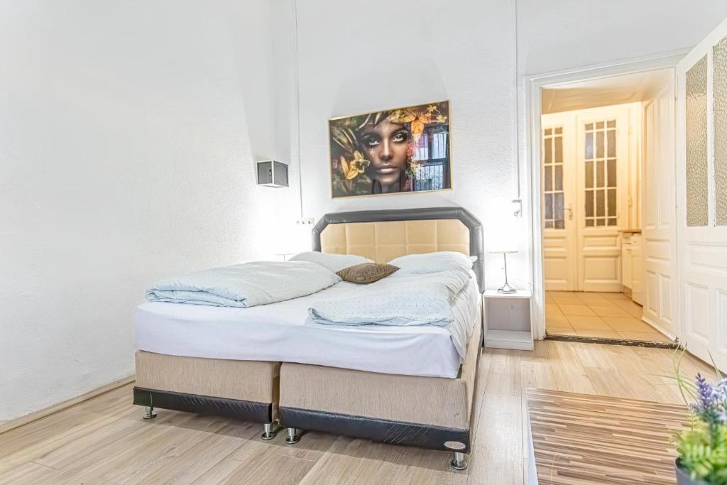 sypialnia z łóżkiem i obrazem na ścianie w obiekcie Chic Apartment- Suitable for Longstays near Matzleinsforferplatz w Wiedniu