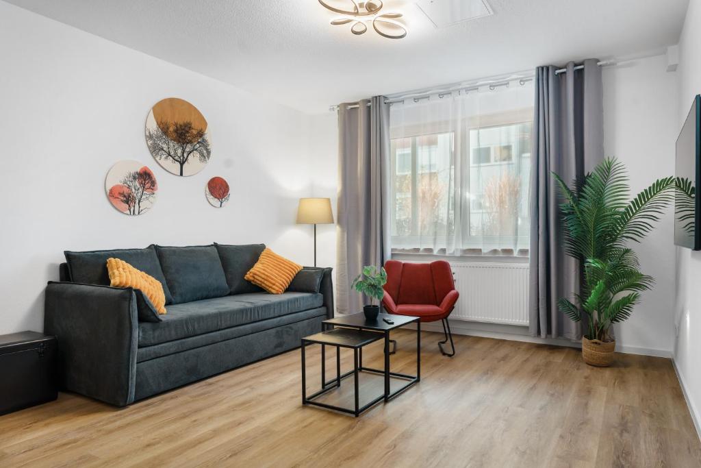 ein Wohnzimmer mit einer Couch und einem Sessel in der Unterkunft ROTH Apartments Solingen-HBF in Solingen