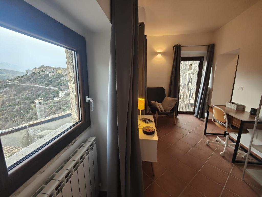 a room with a large window and a table and chair at La casa di Olga e Teodolinda in Pacentro