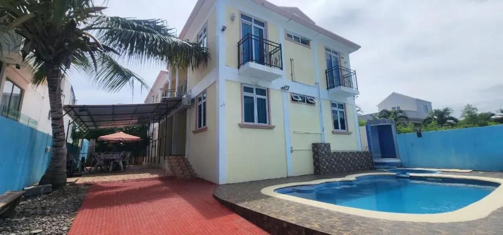 a villa with a swimming pool in front of a house at Charming villa in Flic en Flac with private pool in Flic-en-Flac