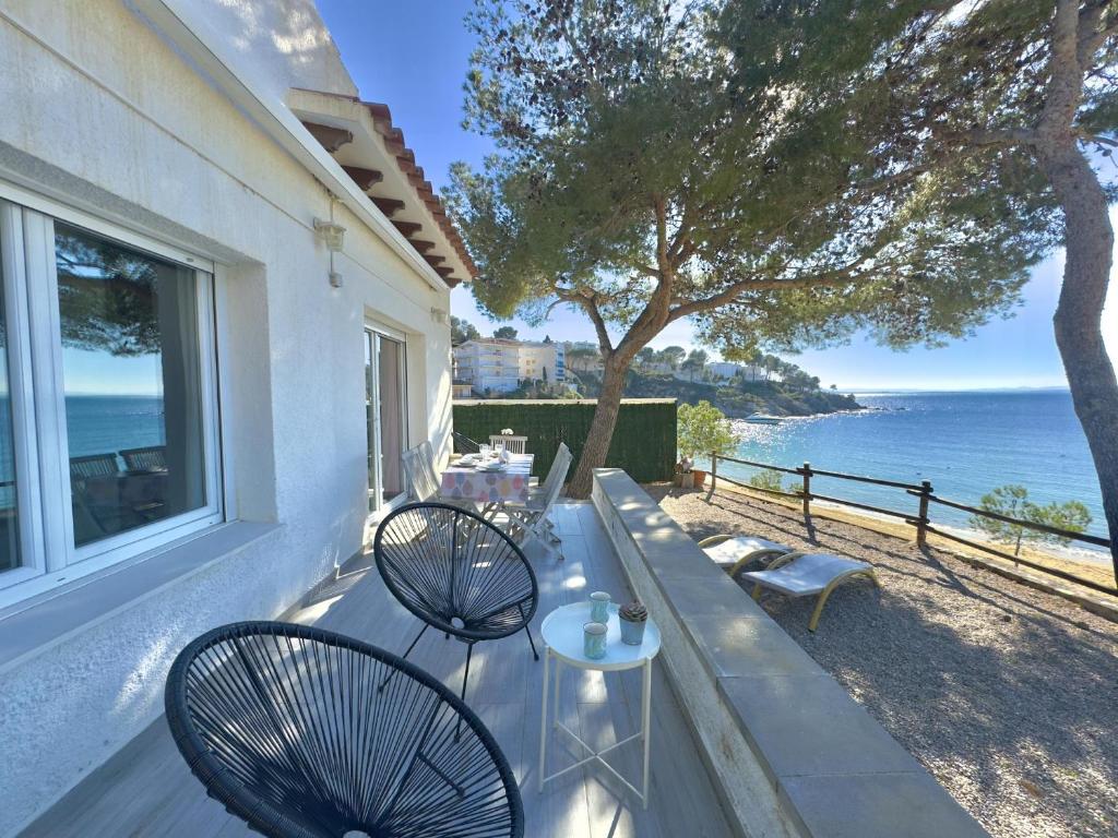 zwei Stühle und ein Tisch auf einem Balkon mit Blick auf den Ozean in der Unterkunft Almadrague Villa in Roses