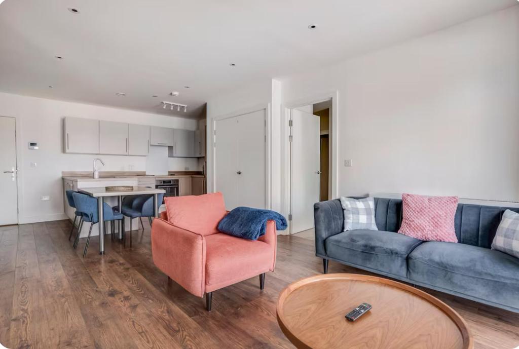 a living room with a couch and a table at Modern, Spacious 2bed, 2bath apartment in Barking in Barking