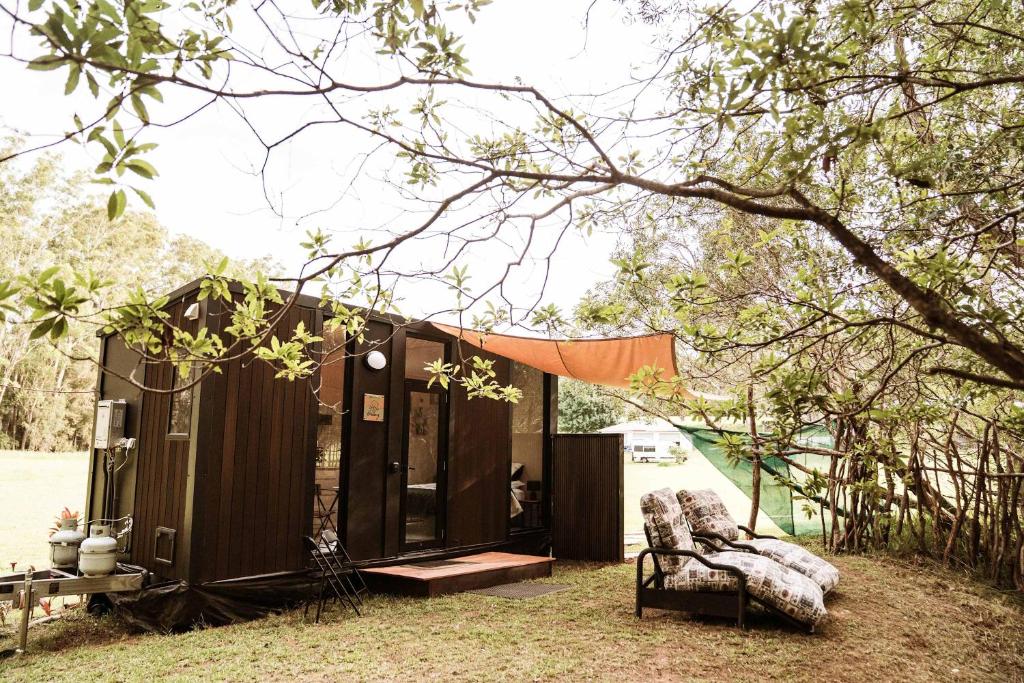 a tiny house in a yard with a tent at Farmhouse 2 at Coffs by Tiny Away in Toormina