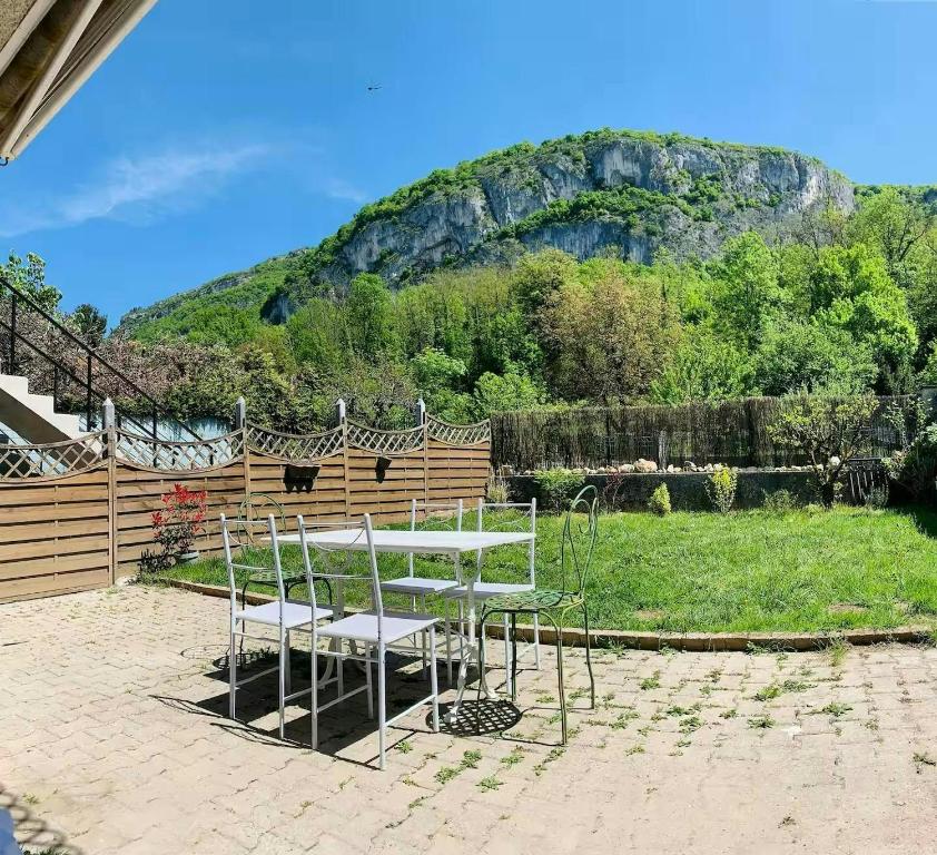 une table et des chaises avec une montagne en arrière-plan dans l'établissement Le Coccoon'Ain, à Virignin