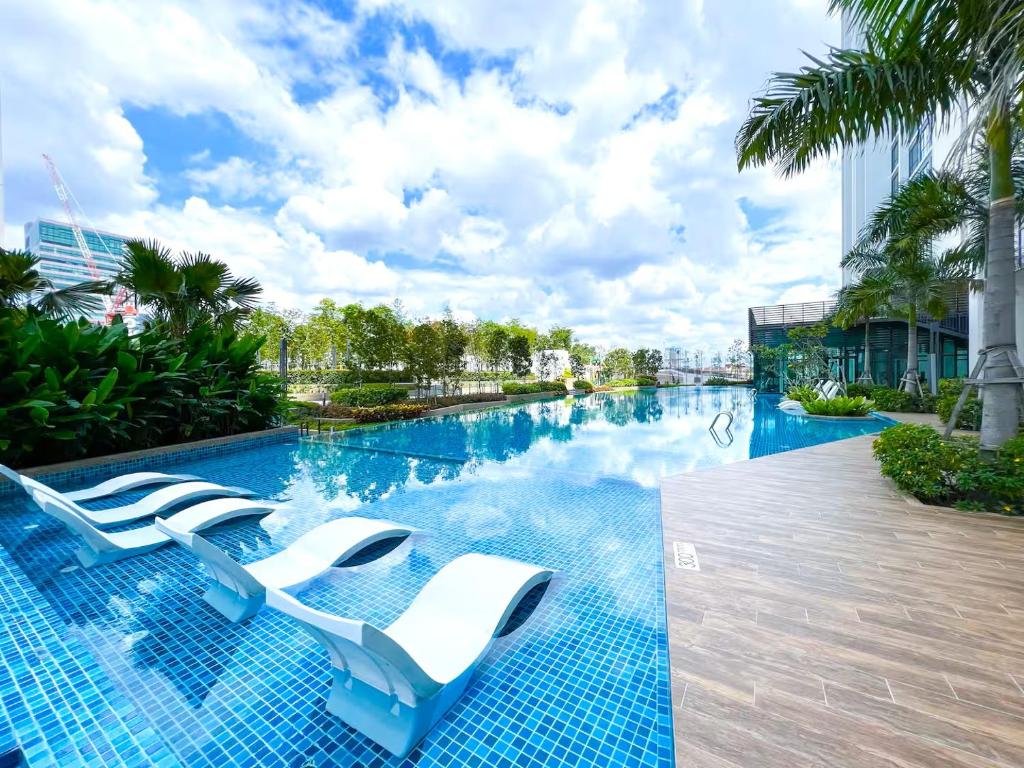 uma piscina com espreguiçadeiras em um prédio em Greenfield Residence Sunway Pyramid em Kuala Lumpur