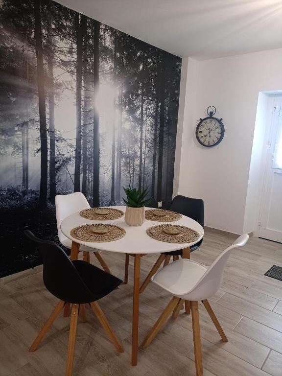 a table and chairs in a room with a forest mural at La Lunita in Valverde