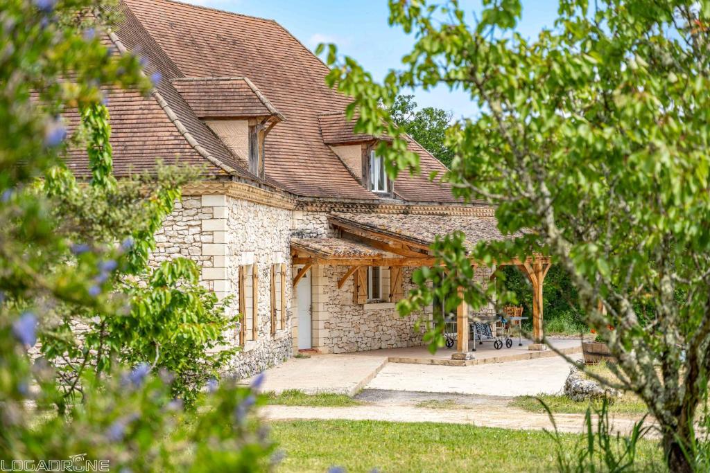 une grande maison en pierre avec une cour arborée dans l'établissement Authentic Charming House WIFI Swimming Pool 10 ppl, à Beaumont-du-Périgord