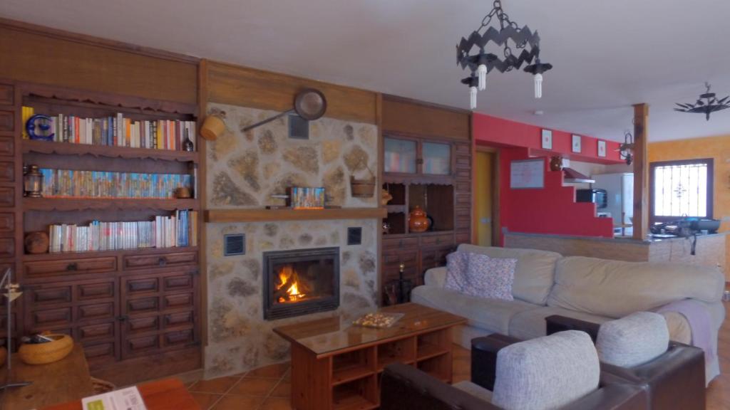 a living room with a couch and a fireplace at La Guarida del Oso in Candeleda