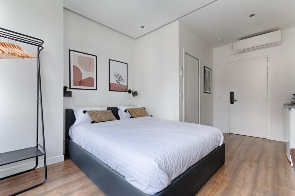 - une chambre blanche avec un grand lit blanc dans l'établissement TBS 312 - Charming studio near Marais district, à Paris