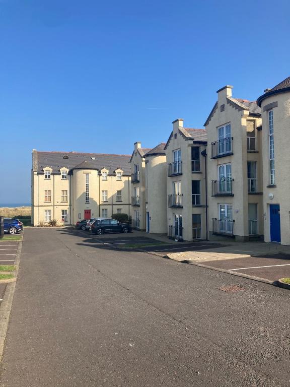 a row of apartment buildings on a street at Golfandbeach in Castlerock