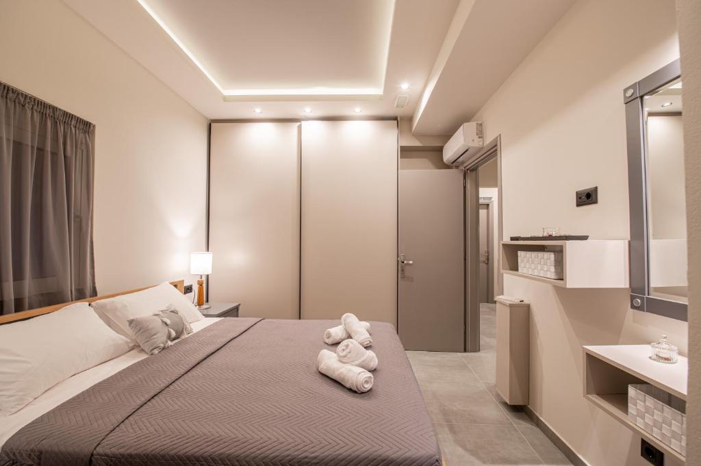 a bedroom with a large bed with two stuffed animals on it at St Paul 25 Urban Apts in Kos Town