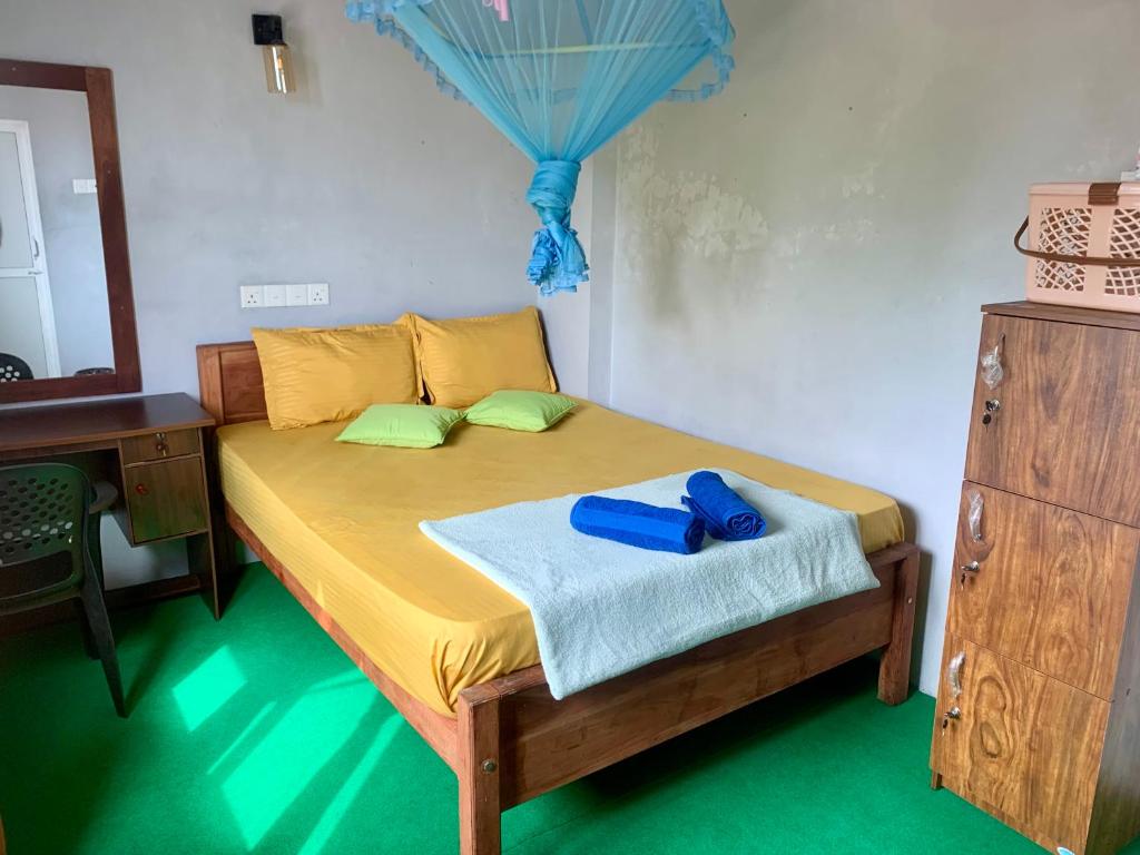 una camera da letto con un letto con specchio e una cassettiera di The Orange House Weligama a Weligama