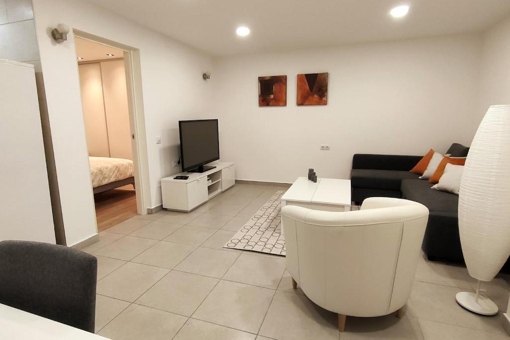 Una televisión o centro de entretenimiento en Cozy detached apartment with pool