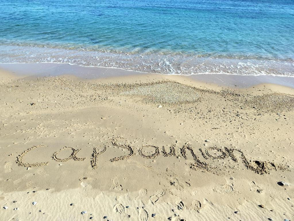 a sign written in the sand on the beach at Cap Sounion, Seafront Apartment in Sounio