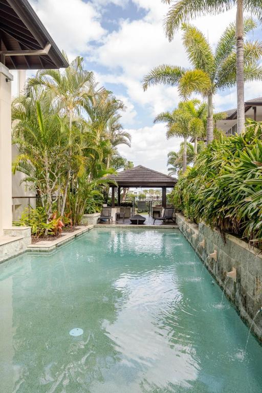 a swimming pool with palm trees and a gazebo at Luxury Romance - 5 to Beach in Casuarina