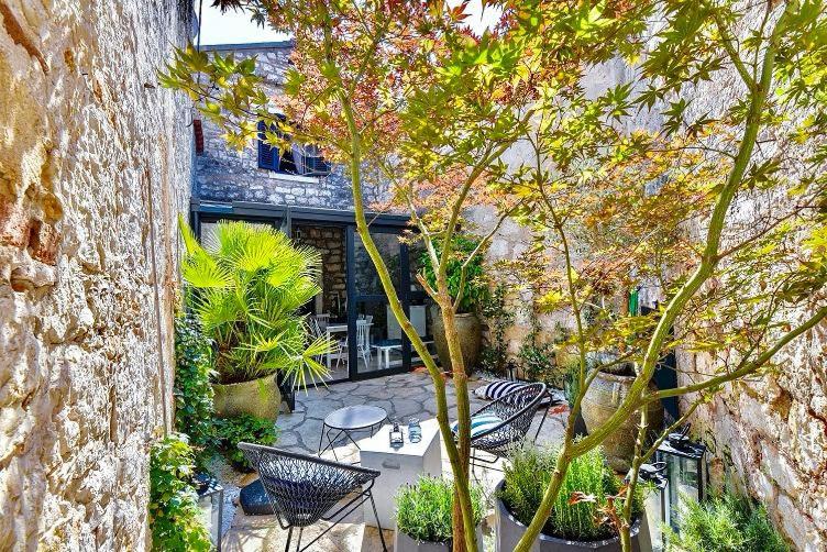 a patio with chairs and a table and trees at Atrium Town House in Rovinj