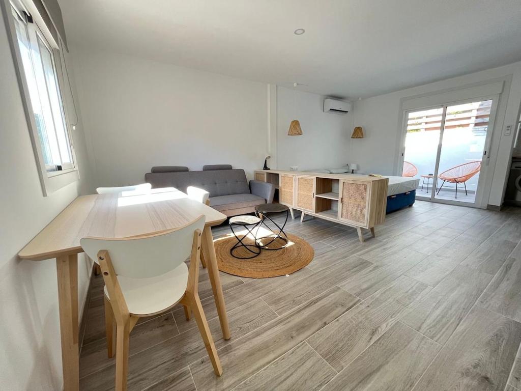 una sala de estar con una mesa y un sofá en Beautiful renovated studio, en Castelldefels
