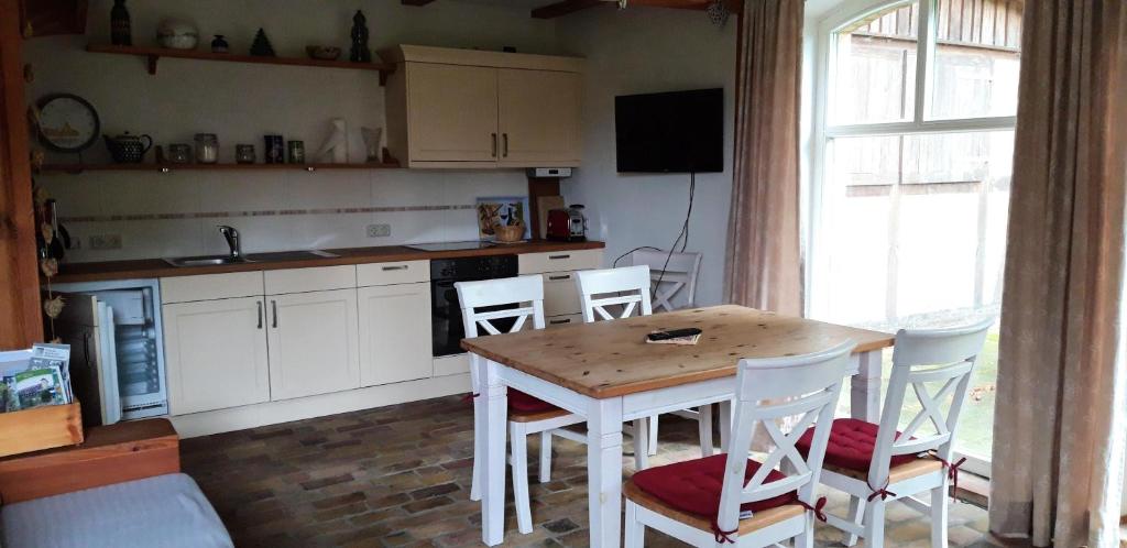 a kitchen with a table and chairs and a window at 75 qm Ferienwohnung für 4 Personen am Naturschutzgebiet Anklamer Stadtbruch in Bugewitz