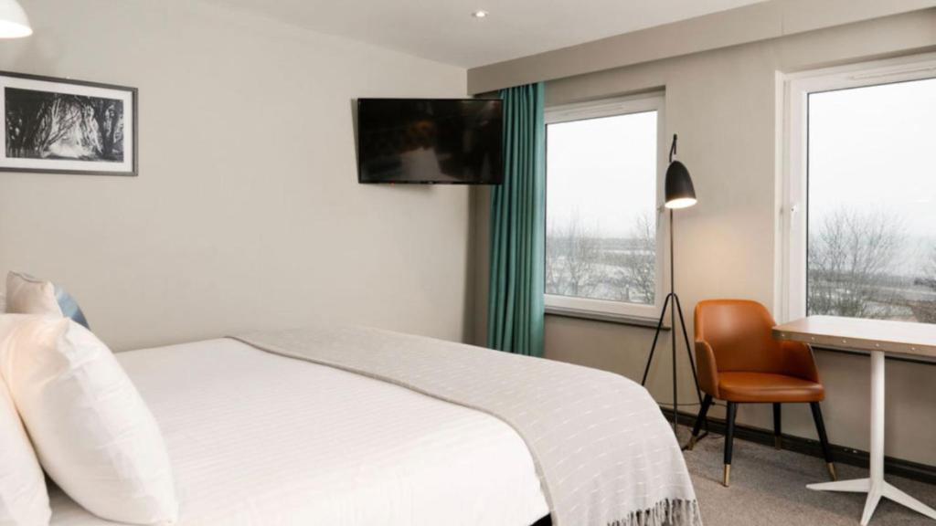 a bedroom with a bed and a desk with a computer at Marine Hotel Ballycastle in Ballycastle