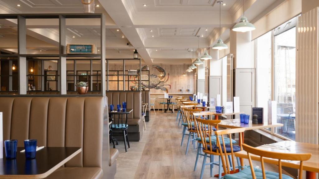 a row of tables and chairs in a restaurant at Marine Hotel Ballycastle in Ballycastle