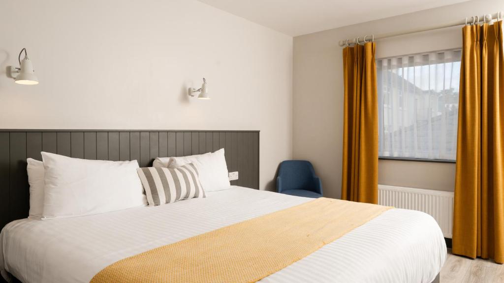a bedroom with a large bed and a window at Marine Hotel Ballycastle in Ballycastle