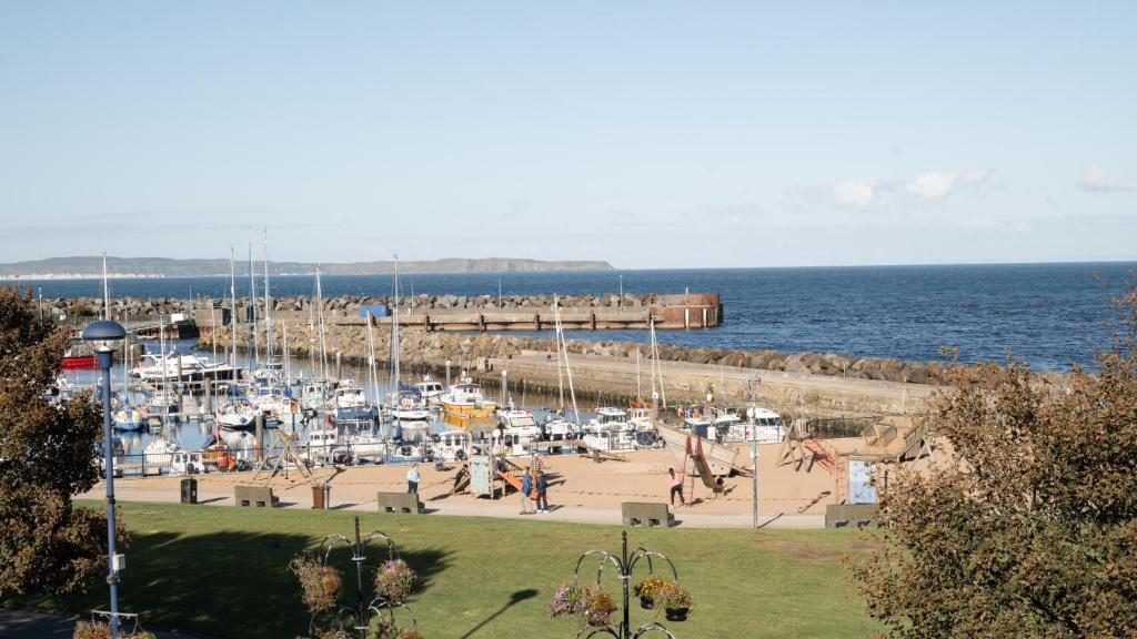 a group of people on a beach near the water at Marine Hotel Ballycastle in Ballycastle