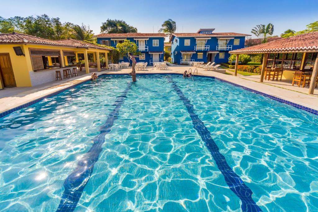 uma grande piscina com água azul em Atlântida Park Hotel em Porto Seguro