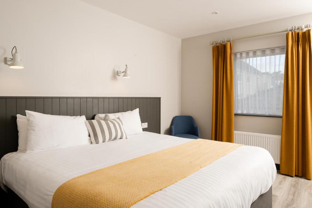 a bedroom with a large bed and a window at Marine Hotel Ballycastle in Ballycastle