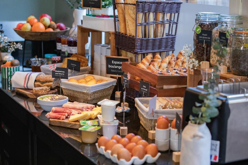 a buffet with bread and other foods on a table at Appart’City Confort Le Bourget - Aéroport in Le Bourget
