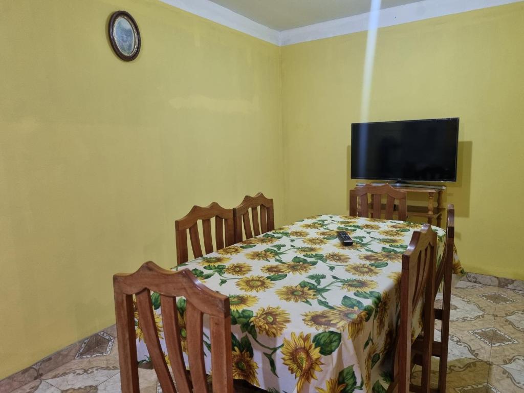 ein Esszimmer mit Tisch und Fernseher in der Unterkunft Costanera in Cafayate