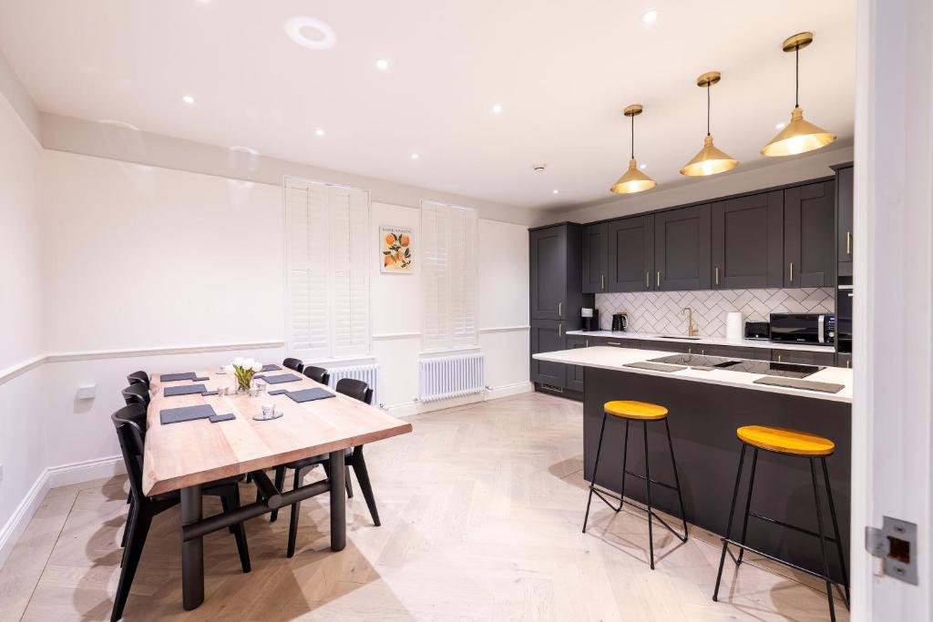 a kitchen with a wooden table and chairs in a kitchen at The Stanley in Teddington