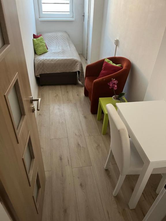 a small living room with a chair and a table at Budget Single Room Old Town in Košice