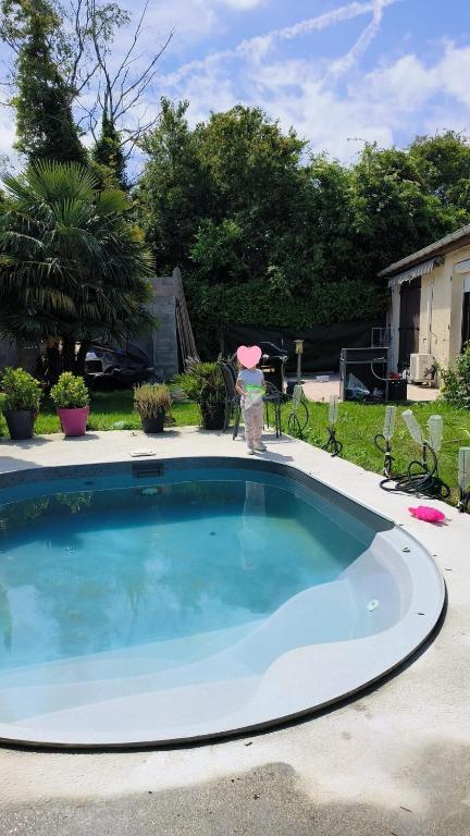 une grande piscine avec une personne debout à côté de celle-ci dans l'établissement home sweet home, à Savigny-le-Temple