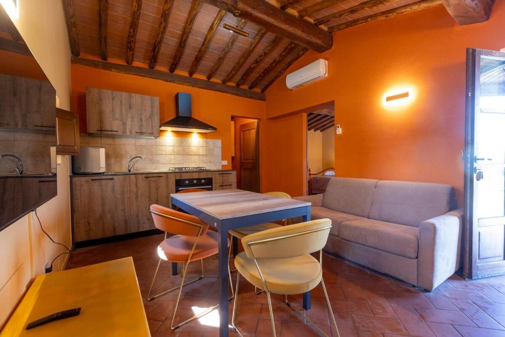 una cucina e un soggiorno con un tavolo e un divano di Appartamento CORBEZZOLO ad Asciano