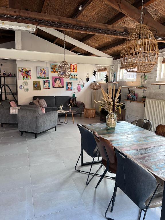 a living room with a large table and chairs at Finca Noordwijk met privé tuin, dichtbij strand in Noordwijk