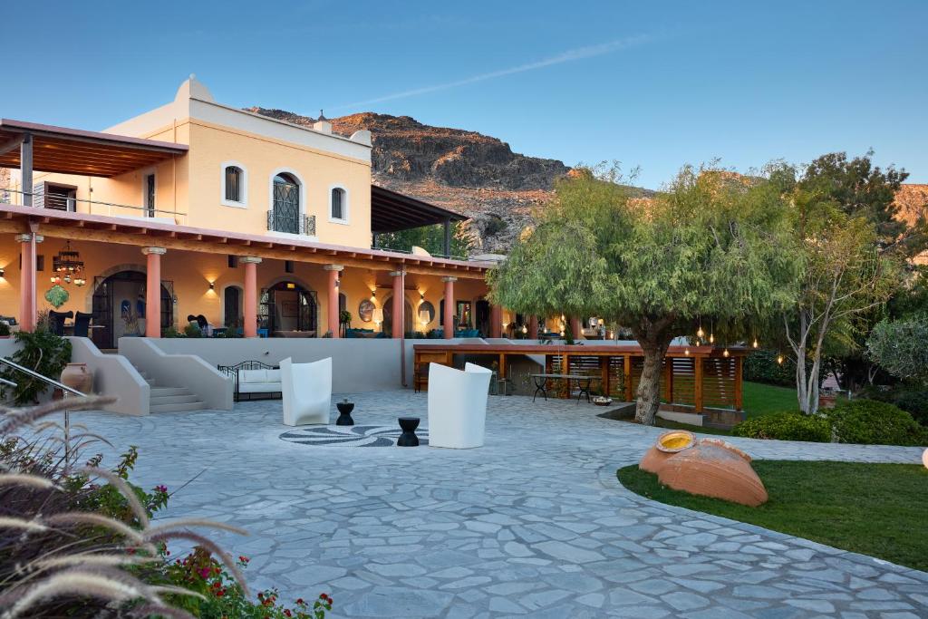 a house with a stone patio in front of it at Palazzo Navarone in Lindos