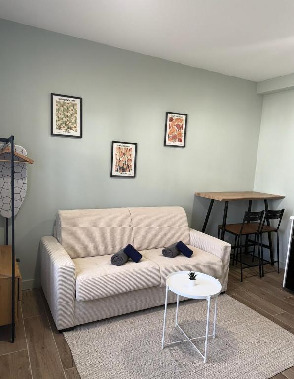un salon avec un canapé blanc et une table dans l'établissement Studio raffiné - Aix hypercentre, à Aix-en-Provence