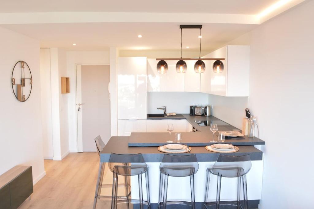 - une cuisine avec une table, des chaises et un comptoir dans l'établissement Appartement 2P vue mer Antibes, à Antibes