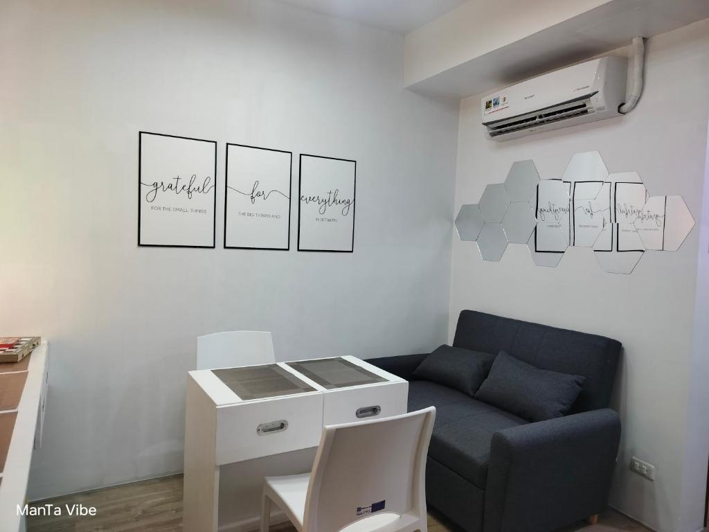 a living room with a couch and a table at ManTa Vibe at Mesavirre Garden Residences in Bacolod