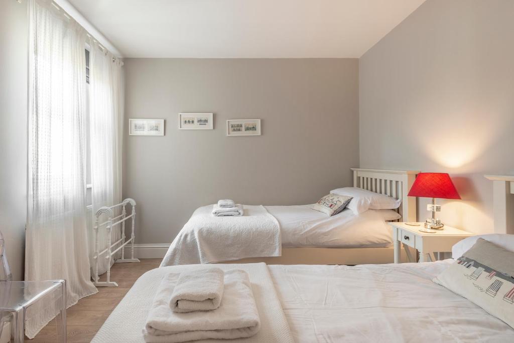 a bedroom with two beds and a window at Carlton Lodge, Two bedroom apartment with parking space in Broadstairs