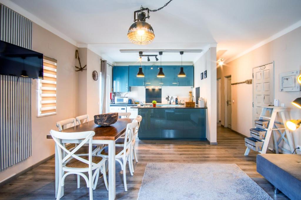 a kitchen and dining room with a table and chairs at SEA URCHIN MILFONTES by Stay in Alentejo in Vila Nova de Milfontes
