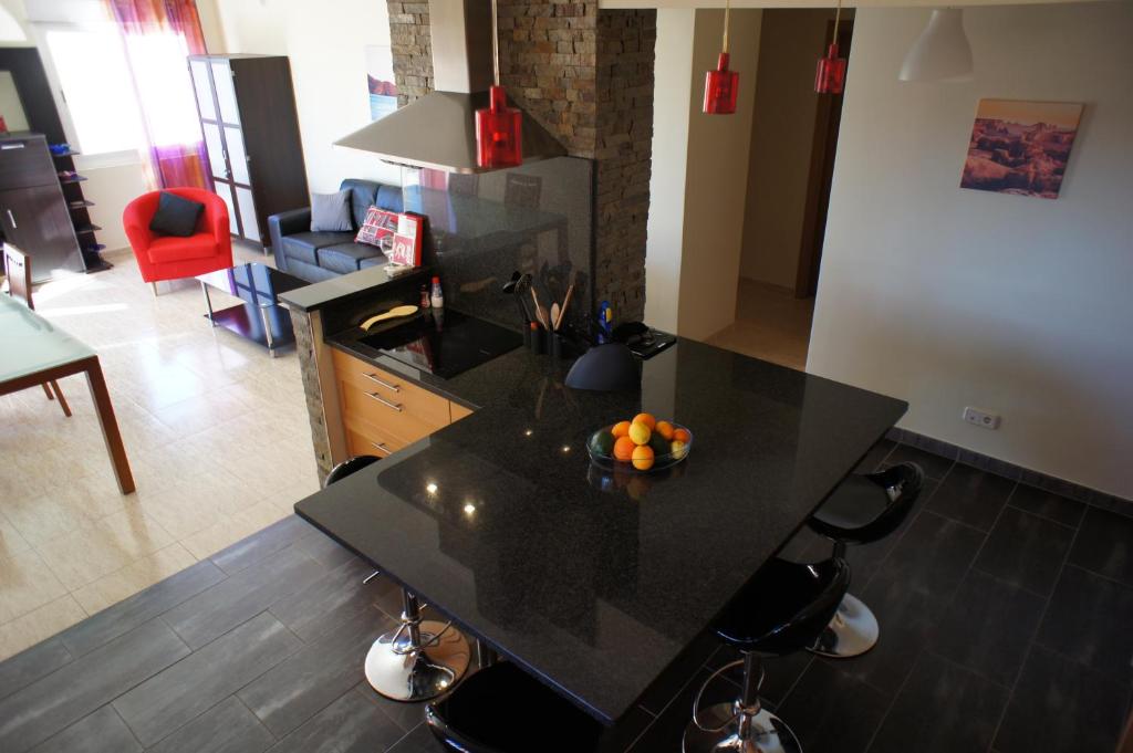 a kitchen with a black island with fruit on it at Sunny Apartment Al-Sakia, Quarteira, Vilamoura in Quarteira