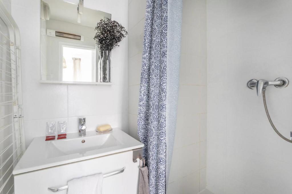 une salle de bain blanche avec un lavabo et une douche dans l'établissement 78GOUF - Appartement confortable au coeur de la ville, à Marseille