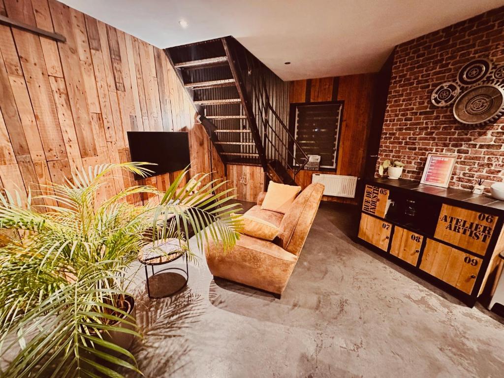 - un salon avec une chaise et un escalier dans l'établissement Le Loft, à Dompierre-sur-Helpe