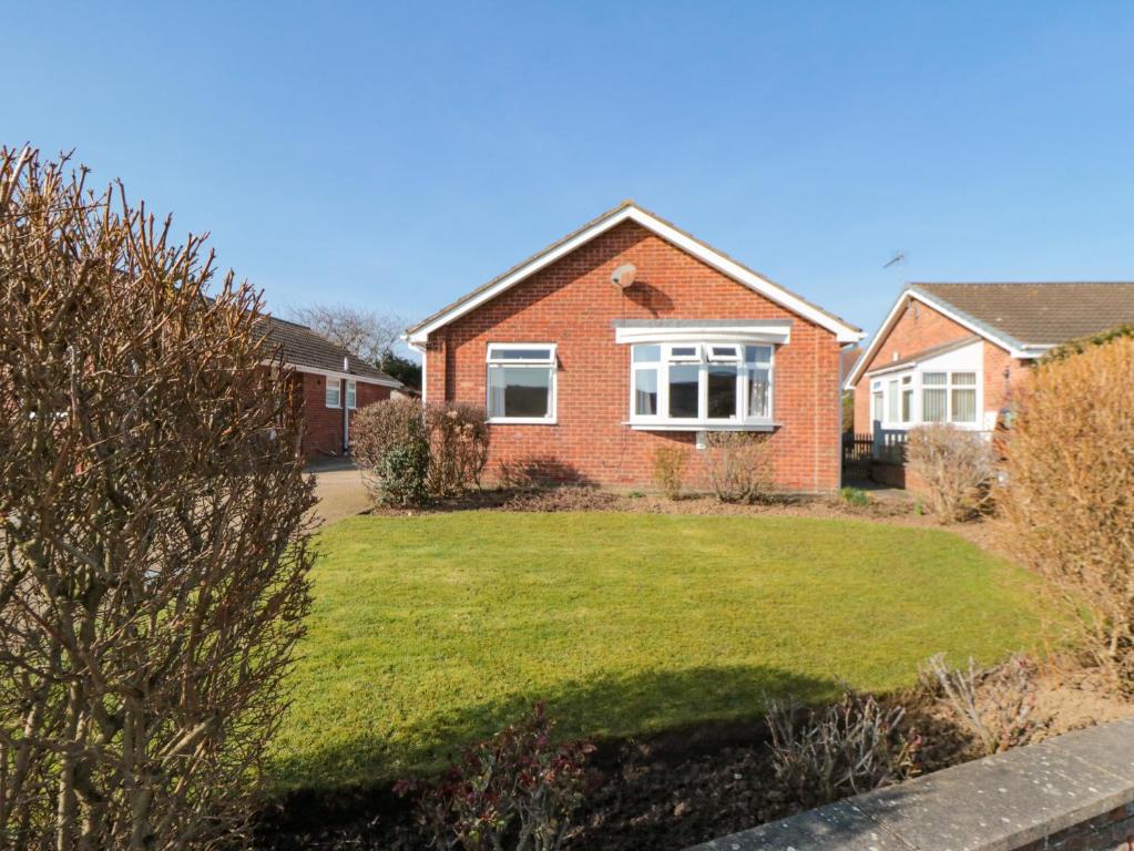 a house with a lawn in front of it at Sycamore in Filey
