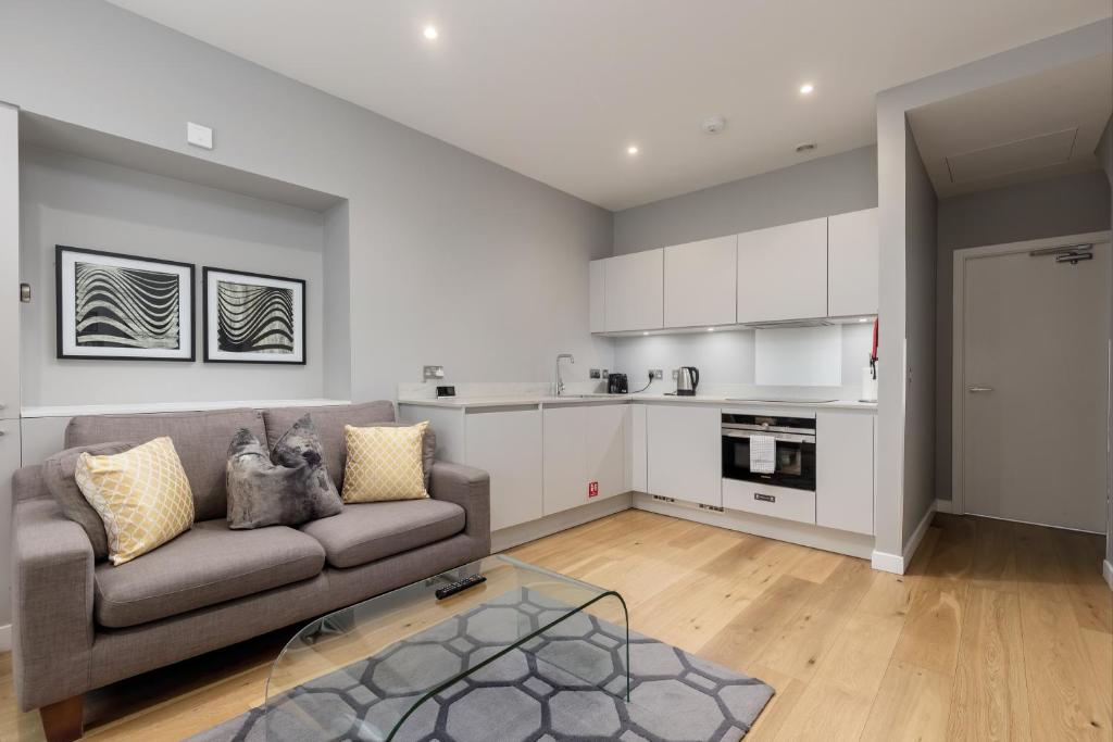 a living room with a couch and a kitchen at Destiny Scotland Apartments at Canning Street Lane in Edinburgh